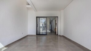 Un couloir moderne avec une porte en verre donnant sur un escalier.
