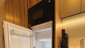 A modern kitchen with a built-in refrigerator, a coffee maker, and wooden cabinetry.