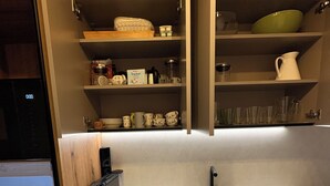 A kitchen with wooden cabinets, a countertop, a sink, and various kitchenware.