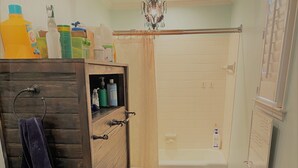 A bathroom with a wooden vanity, a white sink, a toilet, and a shower area. - Charming 1-bedroom "glamping" cottage in peaceful Chapin [see description below] (Chapin)