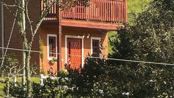 A two-story house with a balcony, surrounded by greenery and hills. - La Domita (Camanducaia)