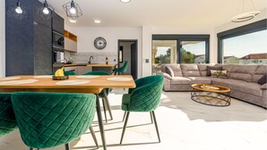 A modern living space with a dining area, a sofa, and a kitchen. - Beautiful home in Vir (Vir)