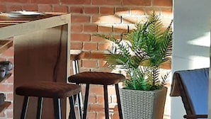 A brick wall, a potted plant, and a bar stool. - Architektenwohnung mit Privatsauna (Großharthau)