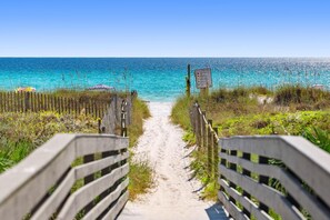 A sandy beach path leading to the ocean with a wooden fence on either side. - 2BR Townhouse Steps from the Beach, Pool + Bikes (Panama City Beach)