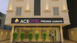 Un hotel con fachada moderna, una entrada destacada y un letrero que indica que es el Premier Ujjayanta.