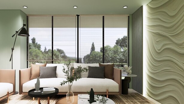 Una sala de estar moderna con un sofá, dos mesas de centro y vistas al exterior a través de grandes ventanales.