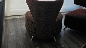 A room with a large window, a patterned armchair, and a wooden floor. - Comfortable and central studio with view to Nahuel Huapi lake (San Carlos de Bariloche)