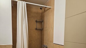 A bathroom with a shower, a bathtub, and a toilet. - Comfortable and central studio with view to Nahuel Huapi lake (San Carlos de Bariloche)