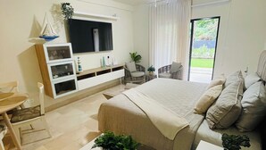 Ein modernes Schlafzimmer mit Bett, Schreibtisch, Stuhl, Fernseher und Deckenventilator.