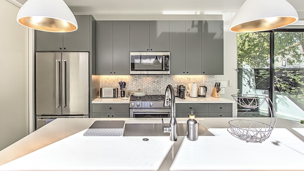 A modern kitchen with grey cabinets, stainless steel appliances, a white countertop, and pendant lighting. - New 2 BDRM Home I Mins to DT Walk to Shops & More (Austin)