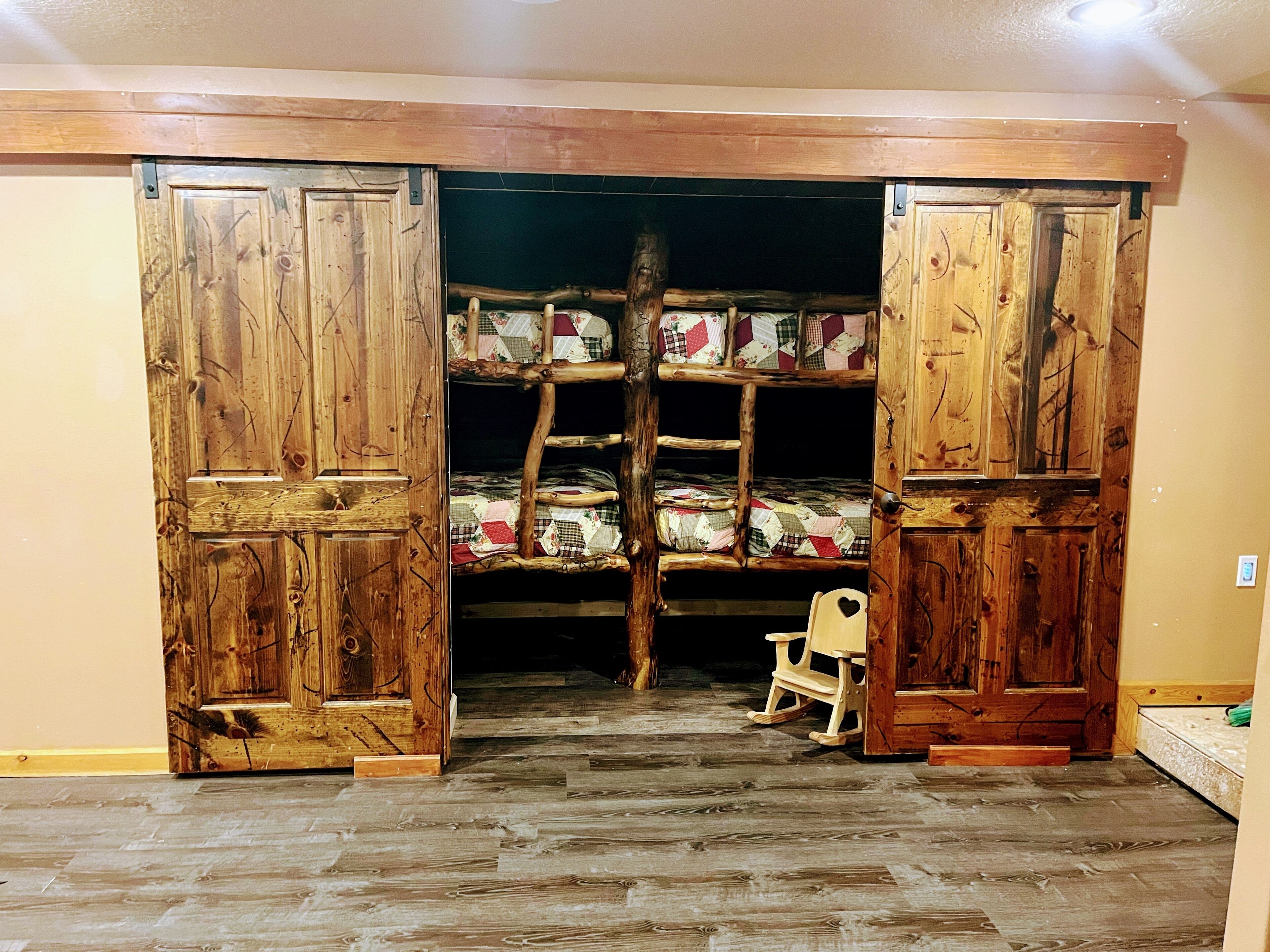 A rustic room with a wooden bunk bed and a rocking chair.