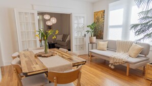Una sala moderna con una mesa de comedor de madera, un sofá y una planta en maceta.
