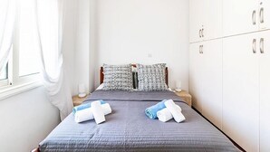 A bedroom with a bed, pillows, and a wardrobe.