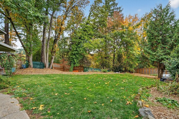 A backyard with a lawn, trees, and a wooden fence. - Mid-Century Escape, Near Forest Park (Portland)