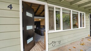 A house with a number '4' on the side, a door leading to a room with a bed and a desk, and a covered porch area. - Mid-Century Escape, Near Forest Park (Portland)