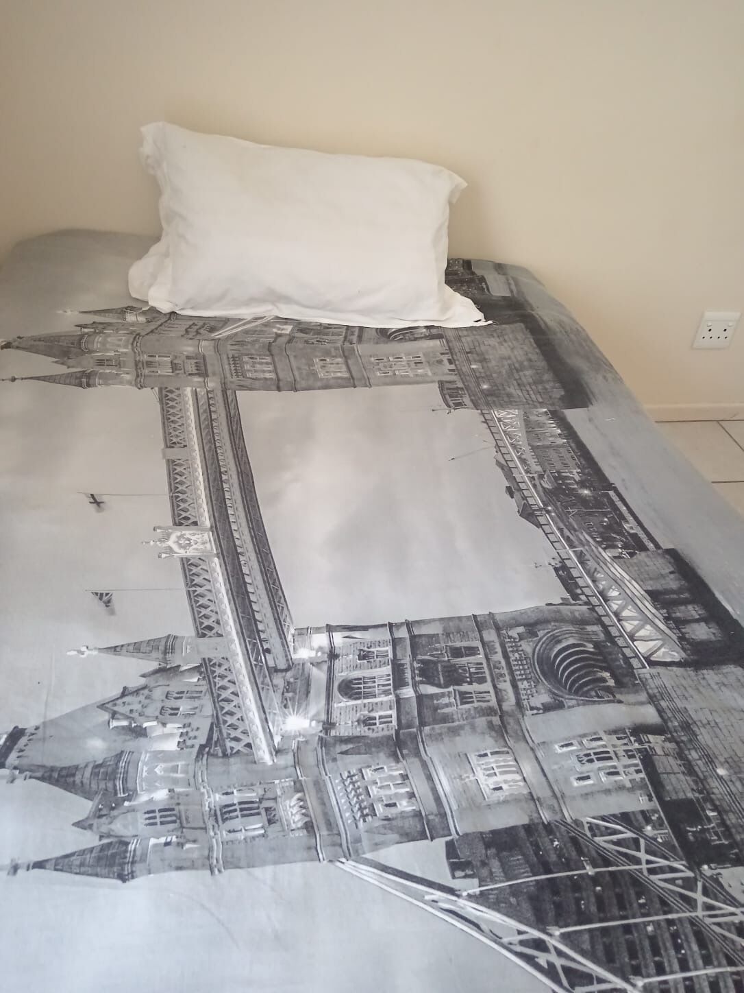 Ein Bett mit einer Bettdecke mit einem Stadtbild-Muster.