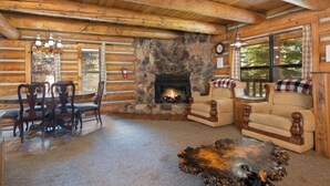 Een chalet inrichting met een stenen open haard, houten meubels en grote ramen.