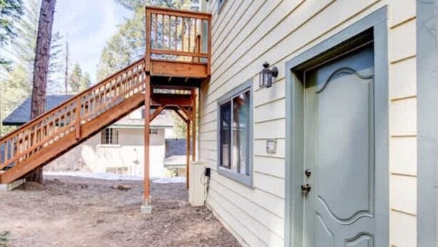 A house with a wooden staircase leading to a deck, a front door, and a window. - Yosemite Woods Lower Unit - Inside Yosemite (Yosemite West)