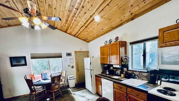 Una cocina acogedora con armarios de madera, una mesa de comedor y un ventilador de techo.