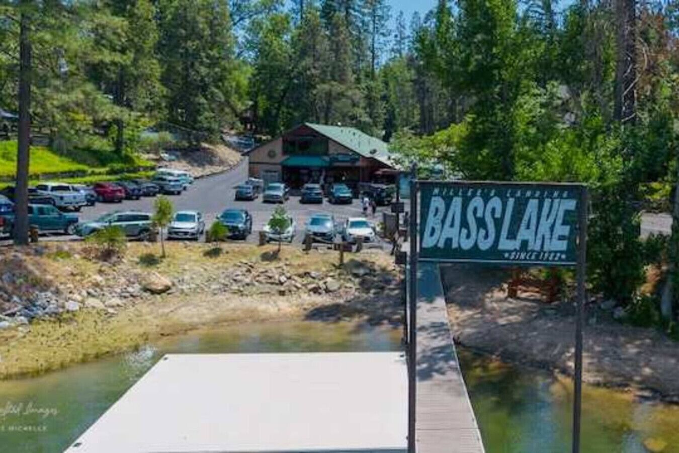 Señal de Bass Lake, con vista a un estacionamiento y un edificio al fondo.
