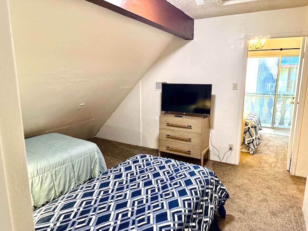 Ein Schlafzimmer mit einem Bett, einer Kommode und einem Fernseher.