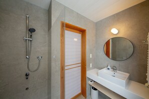 A modern bathroom with a shower, sink, and mirror. - Chihiro Niseko (Kutchan)