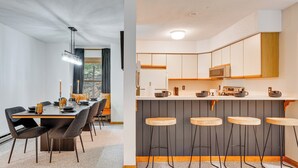 Moderni keittiö, jossa on keskeinen keittiösaareke, baarituolit sekä ruokailutila, jossa on pöytä ja tuolit.
