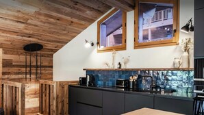 Eine moderne Küche mit Holzelementen, einem großen Fenster und einer eingebauten Sitzbank.