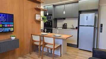 Een koelkast/vriezer, een magnetron, kookgerei, borden en bestek