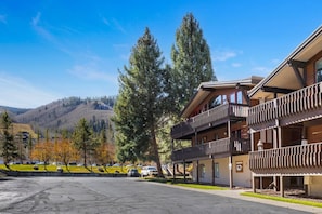 A hotel with a two-story structure, balconies, and a parking lot in a mountainous area. - Vail Condo - Pet Friendly & Steps to Ski Lift (Vail)