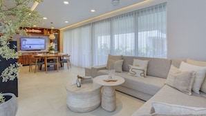 A modern living room with a sofa, coffee table, and dining area. - Vista Natura-Luxury Home Near the Beach (Nuevo Nayarit)