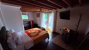 A bedroom with a bed, a desk, a television, and a fireplace. - Lovers Edge Romantic A-Frame: Hot Tub, Sauna & Fire Pit (East Stroudsburg)