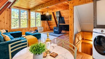 Una habitación acogedora con un sofá, una mesa con una planta, una botella de vino y copas.