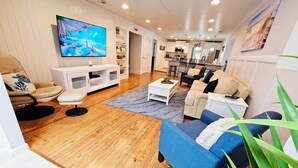 Uma sala de estar moderna com televisão, sofá e mesa de centro.