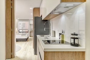 A modern kitchen with a built-in stove, a sink, and a coffee maker. - Haus by Wynwood House (Bogotá)