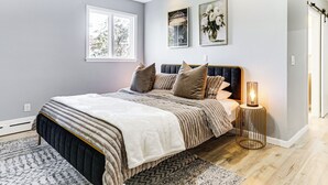 Quarto com cama, abajur e janela.