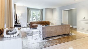 Uma sala de estar moderna com sofá, mesa de jantar e uma grande janela.