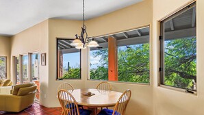 A dining area with a round table, four wooden chairs, and a hanging light fixture. - Sonoran Retreat w/ Hot Tub near Starr Pass Golf & Saguaro Park (Tucson)