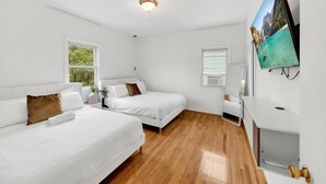 A hotel room with two beds, a TV, and a desk. - Spacious 3BR Luxe Escape near NYC (Yonkers)