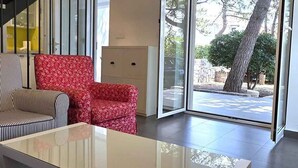 Una sala de estar moderna con un ventanal que da al exterior, una escalera y un sofá.