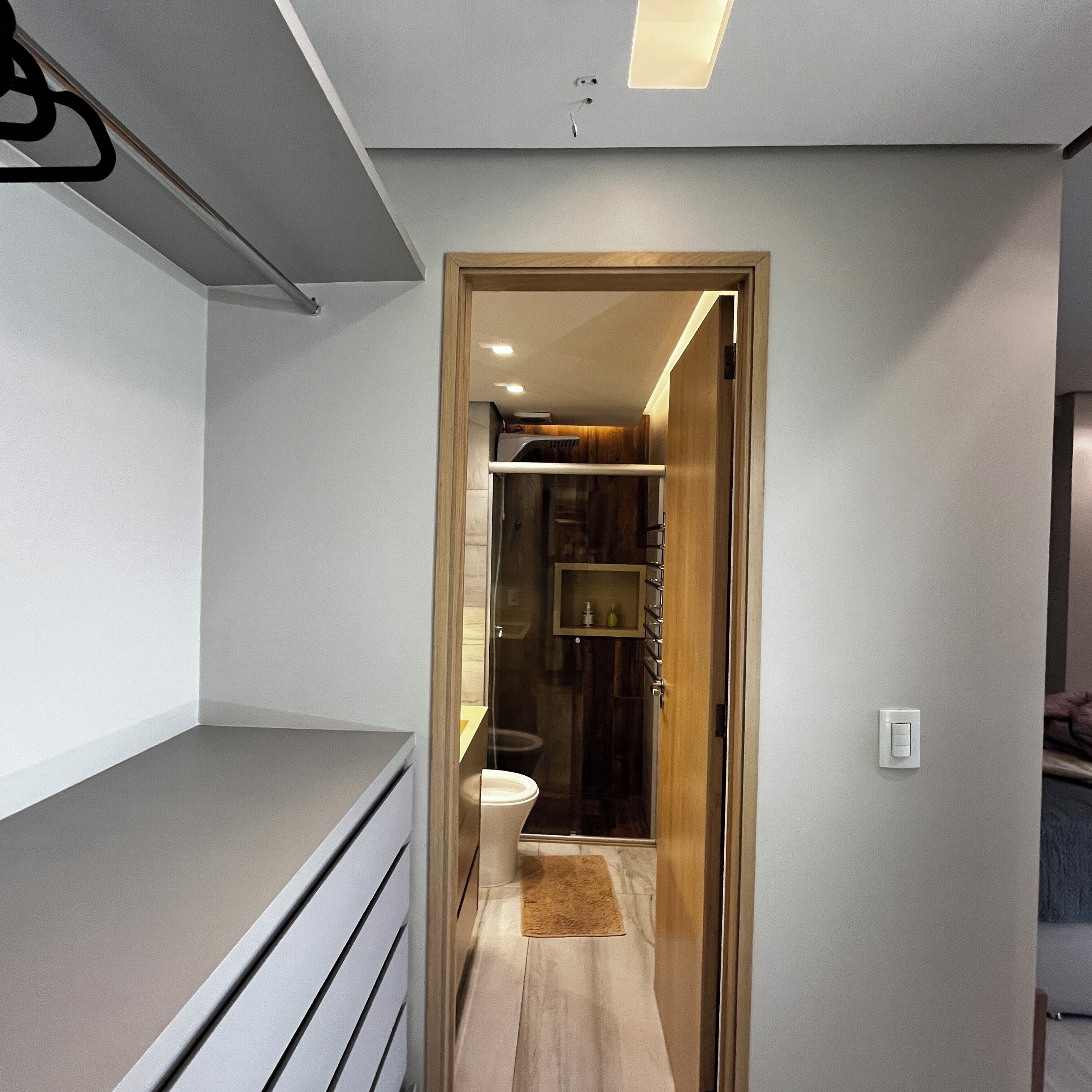 Une salle de bain moderne équipée d’une douche, de toilettes et d’un meuble-lavabo en bois.