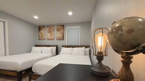 A hotel room with two beds, a wooden nightstand, a globe lamp, and three wall art pieces. - Stylish Retreat with Fire Pit Near Casinos (Atlantic City)