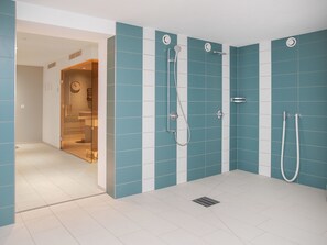 A modern bathroom with blue and white tiles, a glass shower enclosure, and a visible toilet. - La Siala Apt.1 by Interhome (Falera)