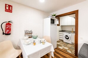 A compact kitchen with a washing machine, a microwave, and a sink. - Brisas de Andrín - Near Andrín Beach, Llanes (Andrin)