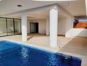 A modern indoor swimming pool with clear blue water, surrounded by white pillars and a tiled floor. - Joli Beach House - Charming Third Floor T1 Center - With Balcony (Sal)