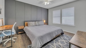 A modern bedroom with a bed, desk, chair, and a ceiling fan. - Cozy Retreat Round Rock|Near Dell|Kalahari|Family (Round Rock)