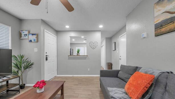 A modern living room with a grey sofa, a wooden coffee table, and a TV. - Cozy Retreat Round Rock|Near Dell|Kalahari|Family (Round Rock)