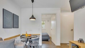 Un apartamento moderno con comedor, sala de estar y dormitorio.