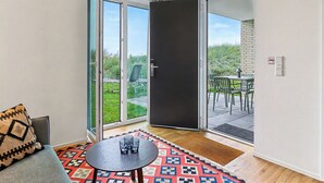 A room with a sliding glass door leading to an outdoor patio with a table and chairs.