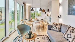 A modern apartment with a dining area, kitchen, and living space.